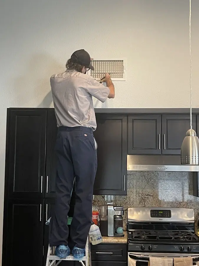 Technician inspecting an air vent during HVAC service in Columbia
